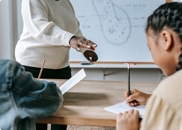 Teacher supporting a student in class — replace with your photo from Figma